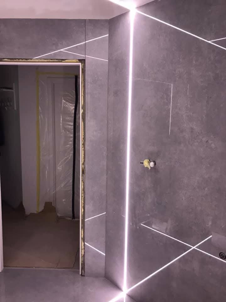 Bagno con grandi lastre e fughe LED a Toruń